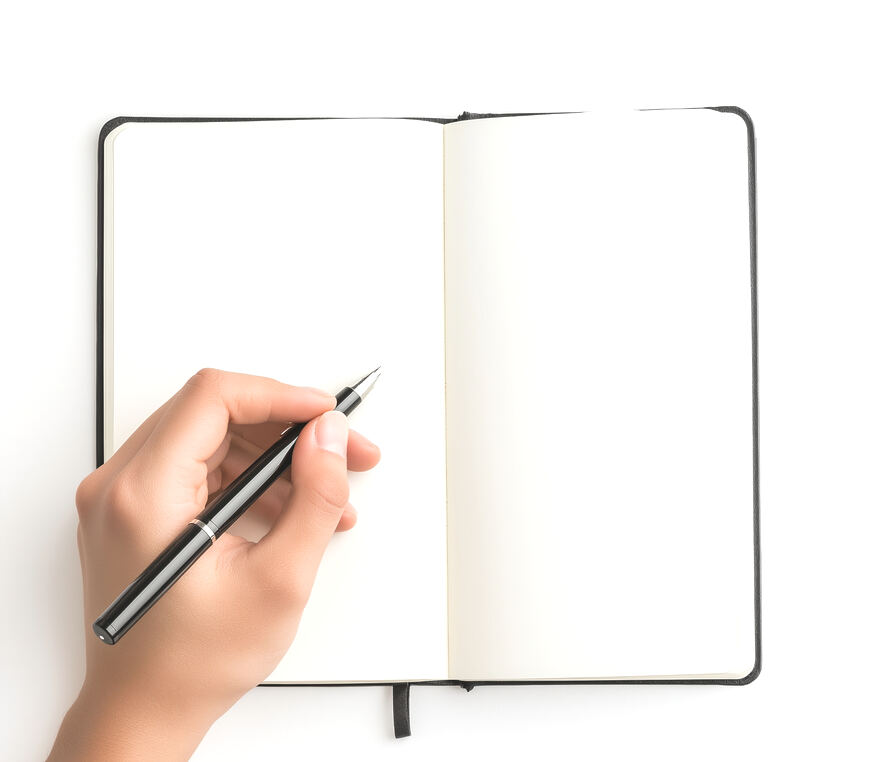A hand writing in an open notebook