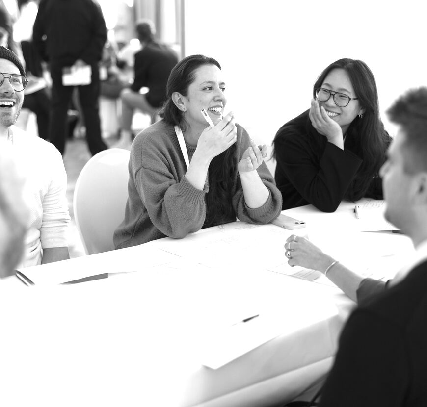 Two designers smiling during a table discussion