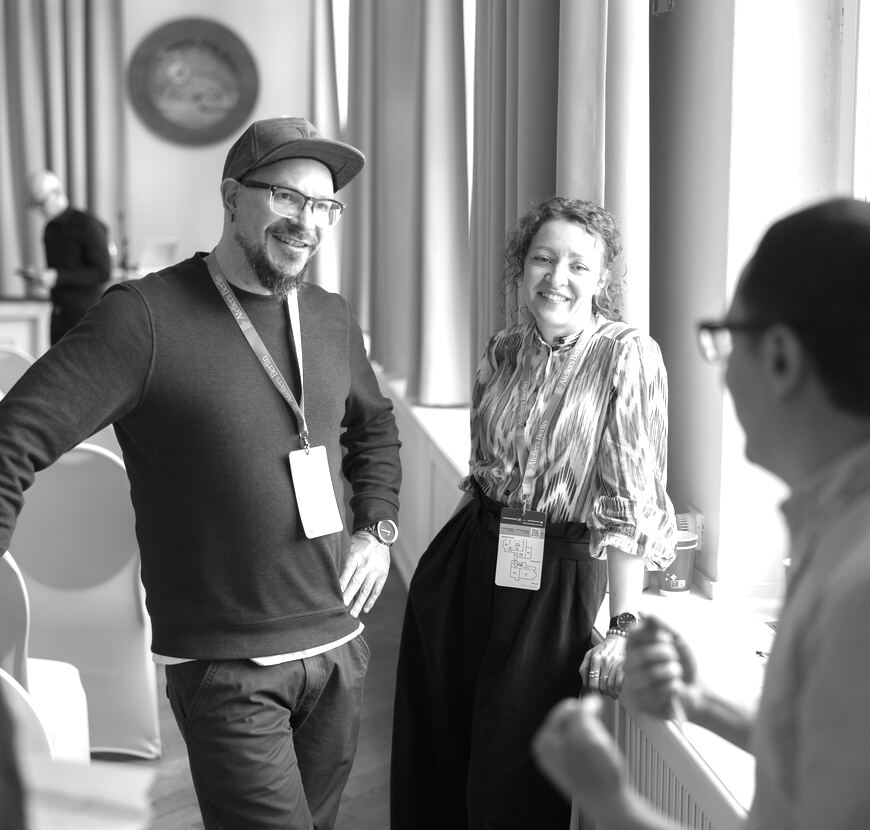 A guest in a cap talking with others